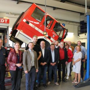 Gruppe vor Feuerwehrfahrzeug